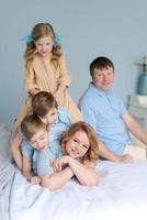 familia alegre jugando juntos en la cama. los padres pasan su tiempo libre foto