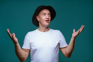 an adult man in a white T-shirt on a blue background. photo