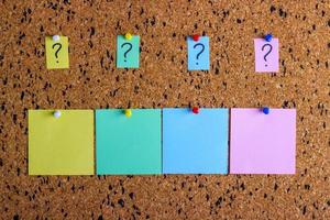 A sticker with a question mark is attached to the cork board. Empty stickers for copy space. photo