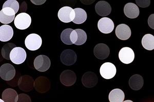 Abstract bokeh of white city lights on black background. defocused and blurred many round light photo