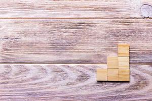 A wooden blocks cube over black wooden textured background with copy space for add word text title. Concept or conceptual Wood block stair or three steps. Cubic photo