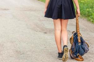 mujer caminando por la carretera con mochila en la mano, concepto de viaje, autostop foto