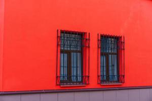 Red facade of the building with wooden windows on which there are iron bars photo