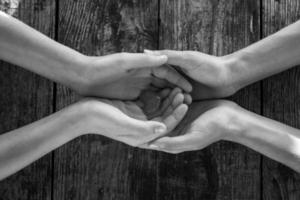 hand in hand on wooden background, mutual aid concept photo