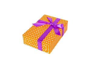 navidad u otro regalo hecho a mano en papel naranja con cinta morada. aislado sobre fondo blanco, vista superior. concepto de caja de regalo de acción de gracias foto