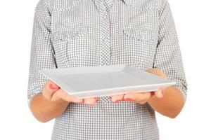 la chica de la camisa a cuadros sostiene un plato mate cuadrado vacío frente a ella. mano de mujer sostenga el plato vacío para su diseño. vista en perspectiva, aislada sobre fondo blanco foto