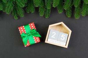 vista superior del abeto, calendario de madera y caja de regalo sobre fondo colorido. el veinticinco de diciembre. feliz navidad con espacio vacío para tu diseño foto
