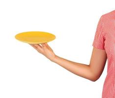 cafe worker points at the camera with an empty round yellow plate in front of him. perspective view photo