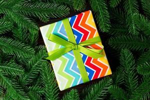 Top view of holiday gift box and fir tree branches with empty space for your design. New year ornament concept photo