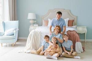 Family portrait caucasian parents with children are sitting on floor photo