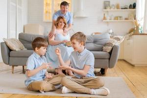 Happy family spend free time in living room, young parents are relaxing on sofa photo