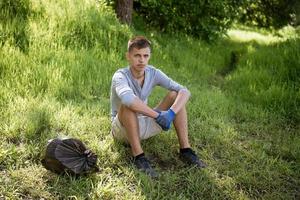 joven descansando después de limpiar el parque foto