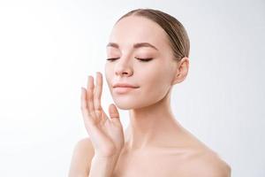 Close up beauty portrait of smiling beautiful half naked woman applying face photo