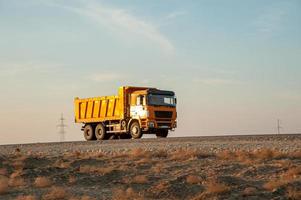 An orange dumper truck in an construction area photo