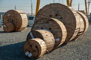un primer plano de grandes bobinas industriales de madera con cable en un sitio de construcción foto