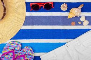 Straw Beach Woman's Hat Sun Glasses Top View Seashell Shorts Flip flops with space for text. photo