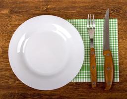 Empty Plate, Fork and Knife on wooden background. photo