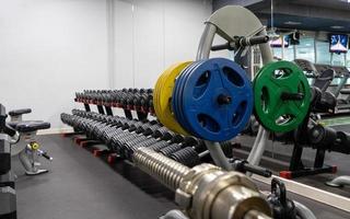 A closeup of weight plates and dumbbells in the sports complex photo