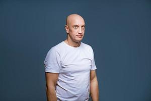 an adult man in a white T-shirt on a blue background. photo