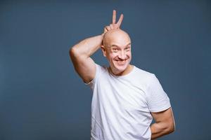 an adult man in a white T-shirt on a blue background. photo