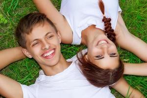 beautiful young couple on green grass with smile on face, happy relationship photo