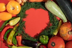 las verduras se colocan alrededor de un lugar vacío. espacio vacío para texto. verduras sobre un fondo rojo. foto