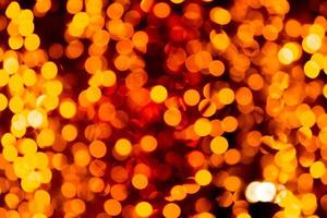 Festive abstract gold background with bokeh defocused and blurred many round yellow light on Christmas dark background photo