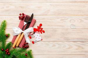 Top view of flatware tied up with ribbon on napkin on wooden background. Christmas decorations and reindeer with empty space for your design. New Year holiday concept photo