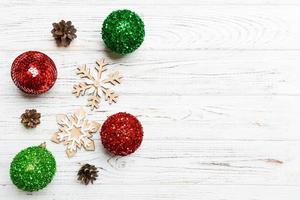 Top view of festive winter composition on wooden background with empty space for your design. Christmas baubles and decorations. New Year concept photo