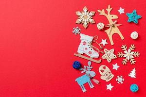 Top view of holiday toys and decorations on red Christmas background. New Year time concept with copy space photo