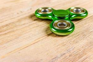 Spinner fidget toy for stress relieving on wood table background with copy space for your creative design project photo