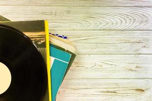 top view of stack of records over wooden table. retro style filter photo