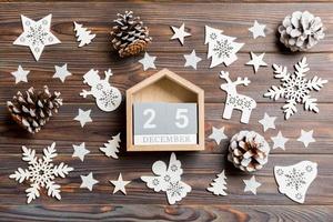 Top view of calendar on Christmas wooden background. The twenty fifth of December. New Year toys and decorations. Holiday concept photo