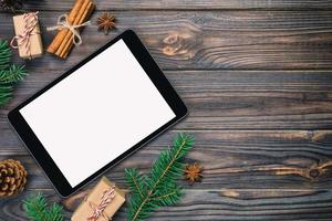 Digital tablet mock up with rustic vintage, toned Christmas wooden background decorations for app presentation. top view with copy space photo