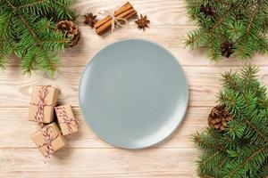 Empty gray matte plate on wooden background with christmas decoration, Round dish. New Year concept photo