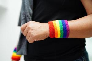 mujer asiática con bandera del arco iris, derechos de símbolos lgbt e igualdad de género, mes del orgullo lgbt en junio. foto