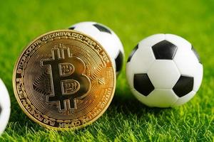 Gold bitcoin with soccer ball or football, cryptocurrency used in online sports betting. photo