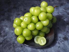 Japanese green grapes or shine muscat grape fruits on grey color background. photo