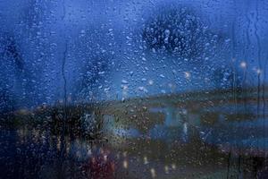 Rainy window, raindrops on the glass against the background of the highway and the bridge. Safe way home. photo