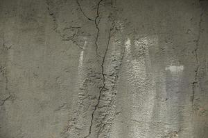 Cracked cement. Concrete wall without treatment. Surface details in cracks. photo