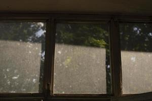 polvo en la ventana. vidrio en balcón. capa de polvo a la luz del sol. foto