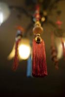 Red cloth hanging from ceiling. Thread brush. Interior decoration. Indian Decoration. Details of light in room. photo