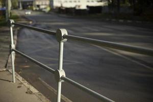 Handrail by road. Pedestrian barrier. Fence along road. photo
