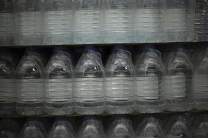 Water bottles in supermarket. Clean water in plastic bottles. Sale of canisters. photo