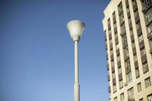 Pole with lamp against sky. Lighting fixture in city. photo