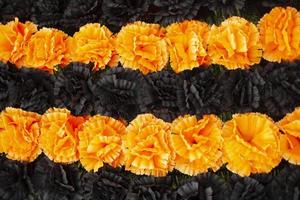 Flowers on monument. Artificial flowers on memorial. Orange and black flower buds. photo