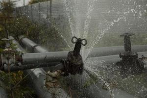 rotura de tubería con agua. accidente de oleoducto el agua caliente fluye de las tuberías. foto