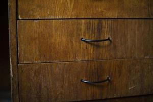 Drawer in table. Wooden boxes in room. Handles on board. photo