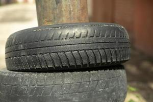 Tires in garages. Old wheels in industrial zone. Old car tire. photo