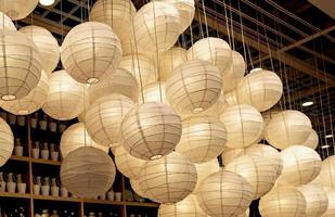 Many white paper lamps hanging from the ceiling photo